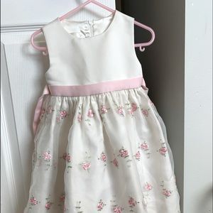 Toddler cream colored dress with pink embroidered flowers.